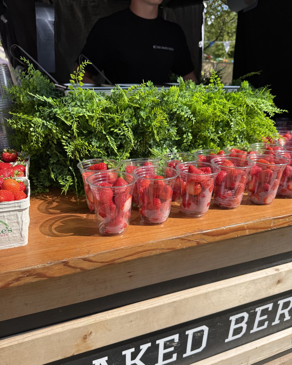 Cups of fresh strawberries lined up on The Naked Berry counter